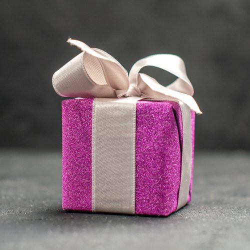top view pink giftbox with white ribbon on dark isolated background free space